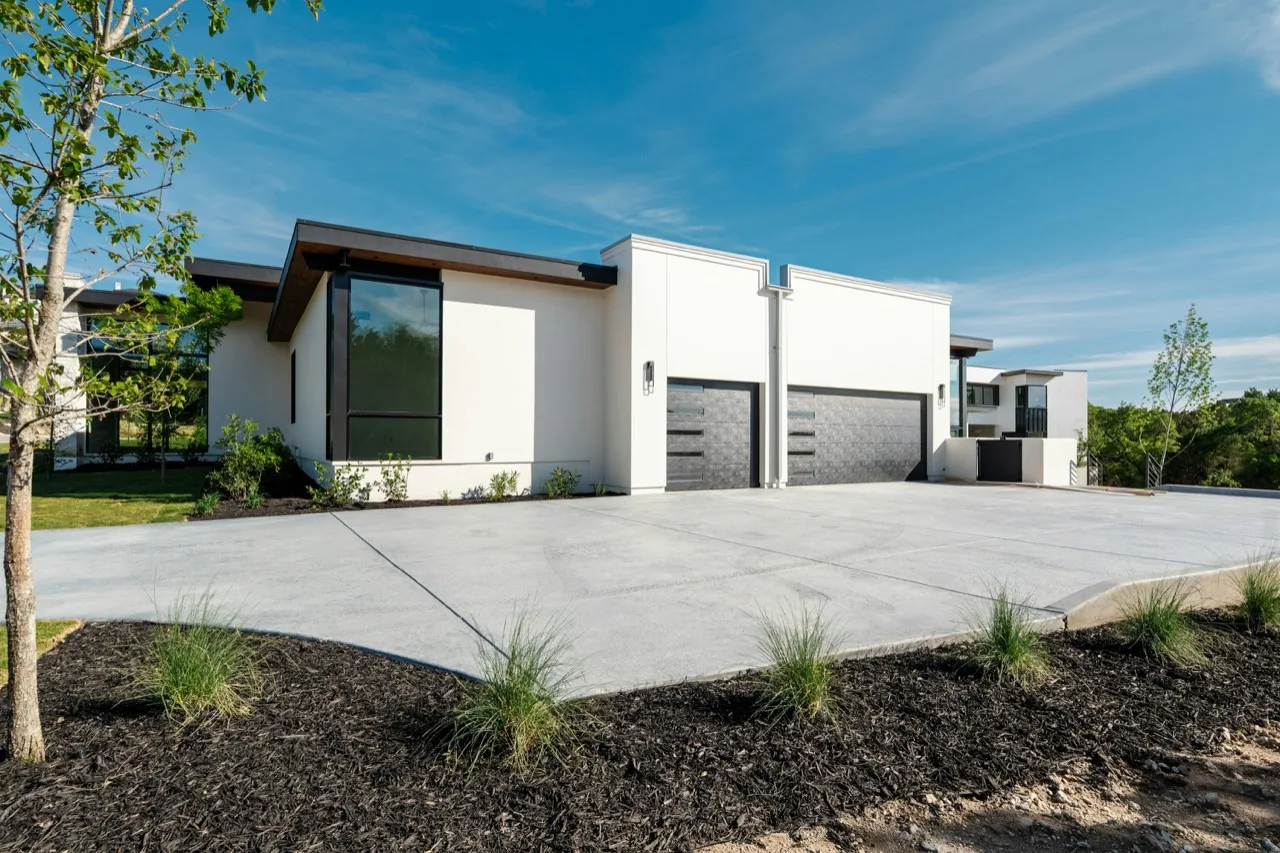 Plain broom-finish concrete driveway in front of a two-car garage